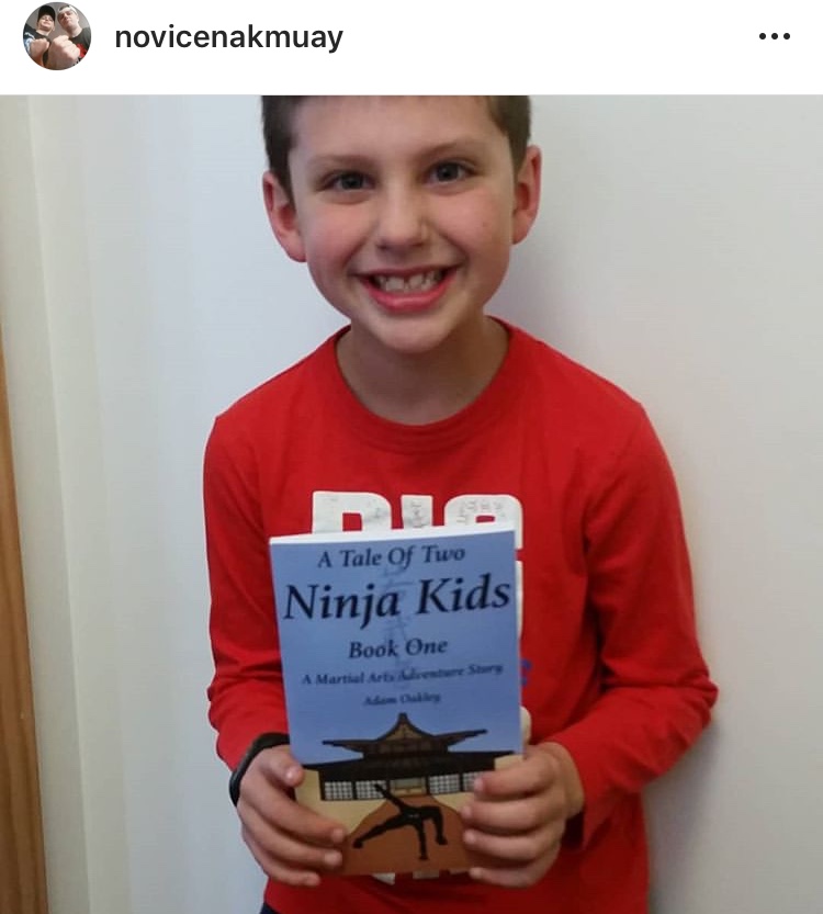 Ninja kid holding ninja kids book - A Tale Of Two Ninja Kids - A Martial Arts Adventure Story Book.