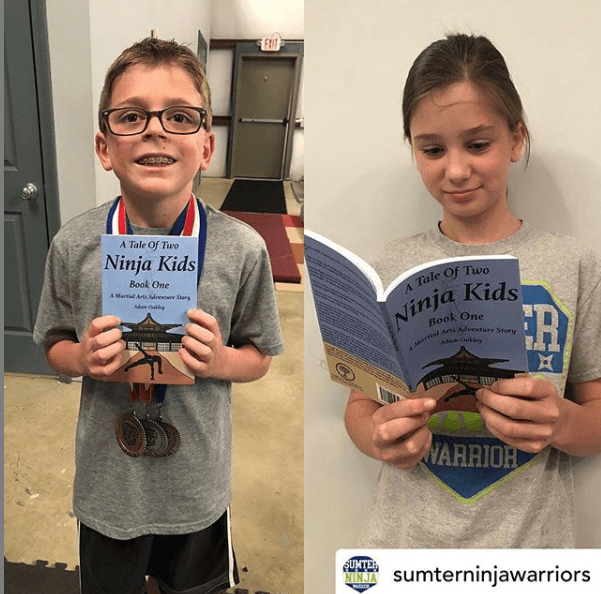 Ninja kid holding ninja kids book - A Tale Of Two Ninja Kids - A Martial Arts Adventure Story Book.